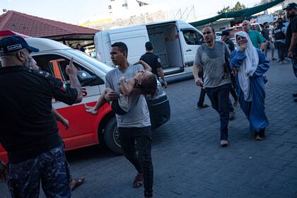 Un palestino lleva a una niña herida al Hospital Shifa, el martes 10 de octubre de 2023, en Ciudad de Gaza. (AP Foto/Fatima Shbair, Archivo)