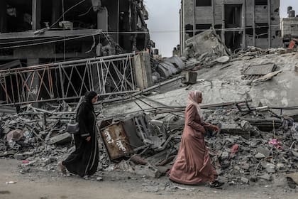 Un palestino pasa junto a un edificio destruido, en medio de las batallas en curso entre Israel y el grupo palestino Hamas