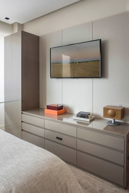 Un panelado de melamina esconde los cables de la TV y completa el diseño del mueble.