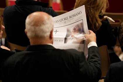 Un participante de las primeras vísperas presididas por el Papa Francisco en la Basílica de San Pedro en el Vaticano lee el periódico del Vaticano L'Osservatore Romano con la noticia de la muerte del Papa Emérito Benedicto XVI