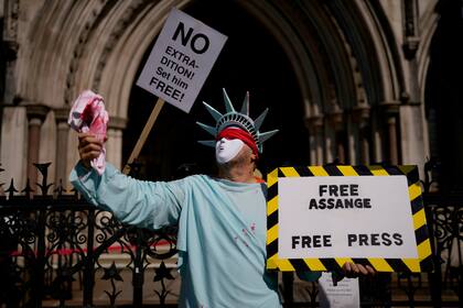 Un partidario de Julian Assange protesta ante la corte donde se realiza la audiencia de extradición del fundador de WikiLeaks, al que Estados Unidos quiere juzgar por espionaje. Londres, miércoles 11 de agosto de 2021. La leyenda en el cartel dice "libertad a Assange" y "libertad de prensa". (AP Foto/Matt Dunham)
