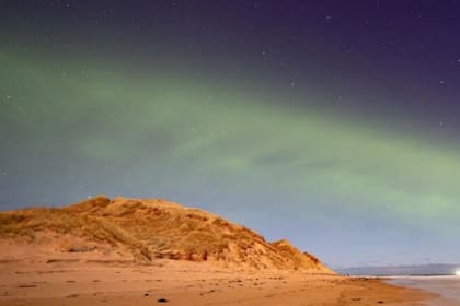 Un patrón de onda constante teñido de verde se puede ver en el evento de la aurora boreal similar a una duna