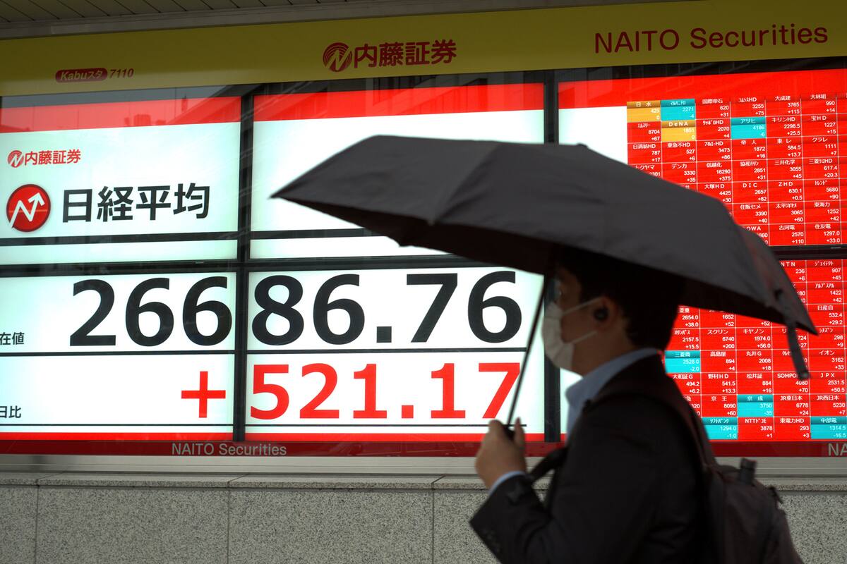 Un peatón pasa junto a un tablero de cotización electrónico que muestra los precios de las acciones en la Bolsa de Valores de Tokio en Tokio el 25 de noviembre de 2020