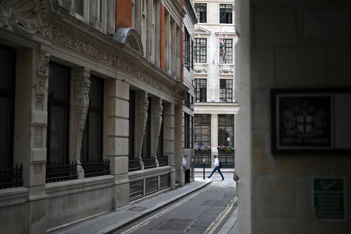 Un peatón solitario en la City, hogar tradicional de la industria financiera. Calles desiertas, restaurantes vacíos, tiendas cerradas: los distritos financieros de Londres permanecen en gran parte abandonados por trabajadores que aún están preocupados por la pandemia y reacios a volver a la vida de