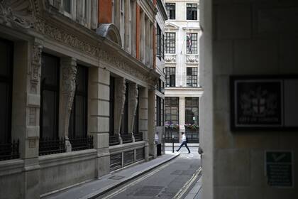 Un peatón solitario en la City, hogar tradicional de la industria financiera. Calles desiertas, restaurantes vacíos, tiendas cerradas: los distritos financieros de Londres permanecen en gran parte abandonados por trabajadores que aún están preocupados por la pandemia y reacios a volver a la vida de