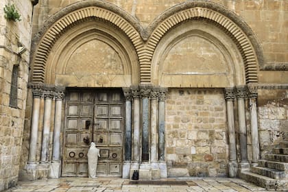 Un peregrino cristiano vestido como Jesucristo se para frente a la puerta cerrada de la Iglesia del Santo Sepulcro en la Ciudad Vieja de Jerusalén el 10 de abril de 2020