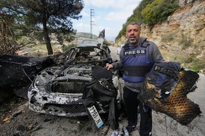 Un periodista exhibe equipo de seguridad quemado tras un ataque aéreo israelí contra un automóvil en la ciudad de Jezzine, al sur del Líbano, en el que murieron dos reporteros y un camarógrafo (AP/Mohammed Zaatari)