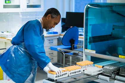 Un personal médico del laboratorio del Hospital Karolinska opera una máquina utilizada en el proceso de prueba de PCR para las personas que creen que pueden estar infectadas con el nuevo coronavirus, el 7 de diciembre de 2020 en Solna, cerca de Estocolmo