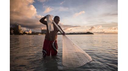 Un pescador local en una playa en la bahía de Tumon