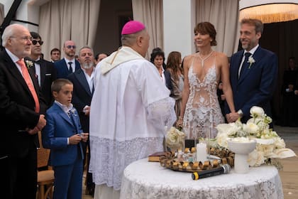Un plano más amplio de la foto de apertura de esta nota en donde puede verse a los novios, durante la bendición de monseñor Adrián, de la parroquia San Expedito de Garín, de Buenos Aires. A la izquierda, de corbata naranja, Roberto Gallo, papá del novio; y a su derecha, con
traje azul, Marcial, el hijo de 9 años de Juan Manuel, quien entregó los anillos