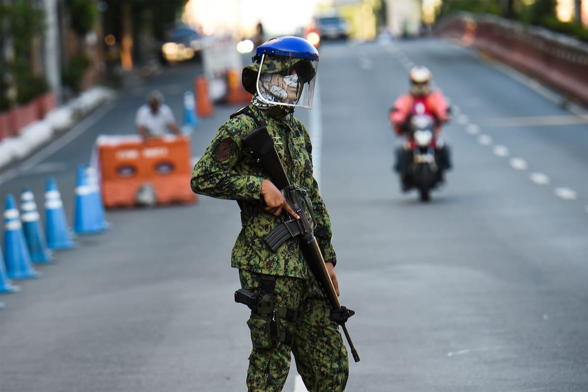 Un policía con una máscara hace guardia en un puesto de control después de que el gobierno impuso una cuarentena como medida preventiva contra el nuevo coronavirus en Manila el 25 de marzo de 2020