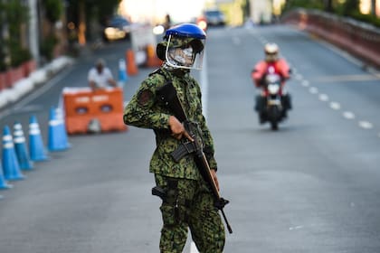 Un policía con una máscara hace guardia en un puesto de control después de que el gobierno impuso una cuarentena como medida preventiva contra el nuevo coronavirus en Manila el 25 de marzo de 2020