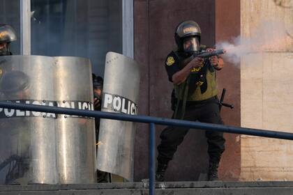 Un policía dispara gases lacrimógenos para dispersar a simpatizantes del destituido presidente Pedro Castillo, el lunes 12 de diciembre de 2022, en Lima. (AP Foto/Martin Mejia)
