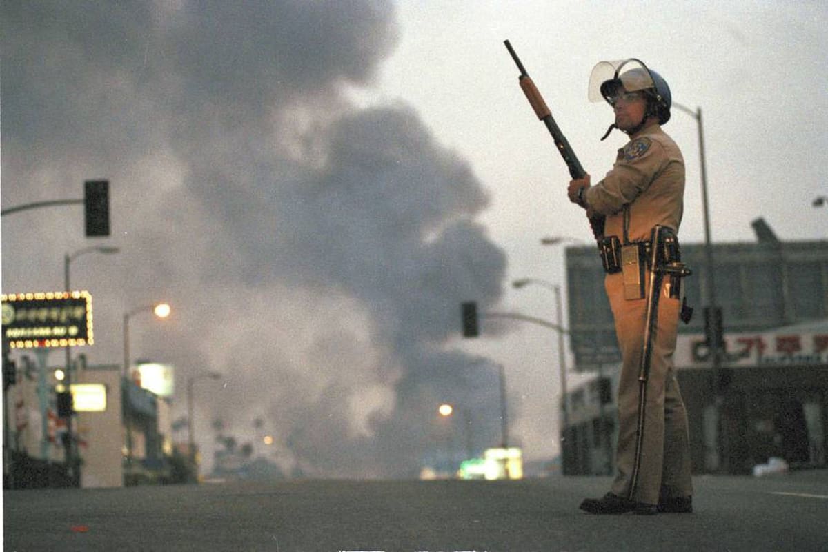 Un policía en el sur de Los Ángeles en el segundo día de disturbios, el 30 de abril de 1992, por el caso Rodney King (Crédito: AP)