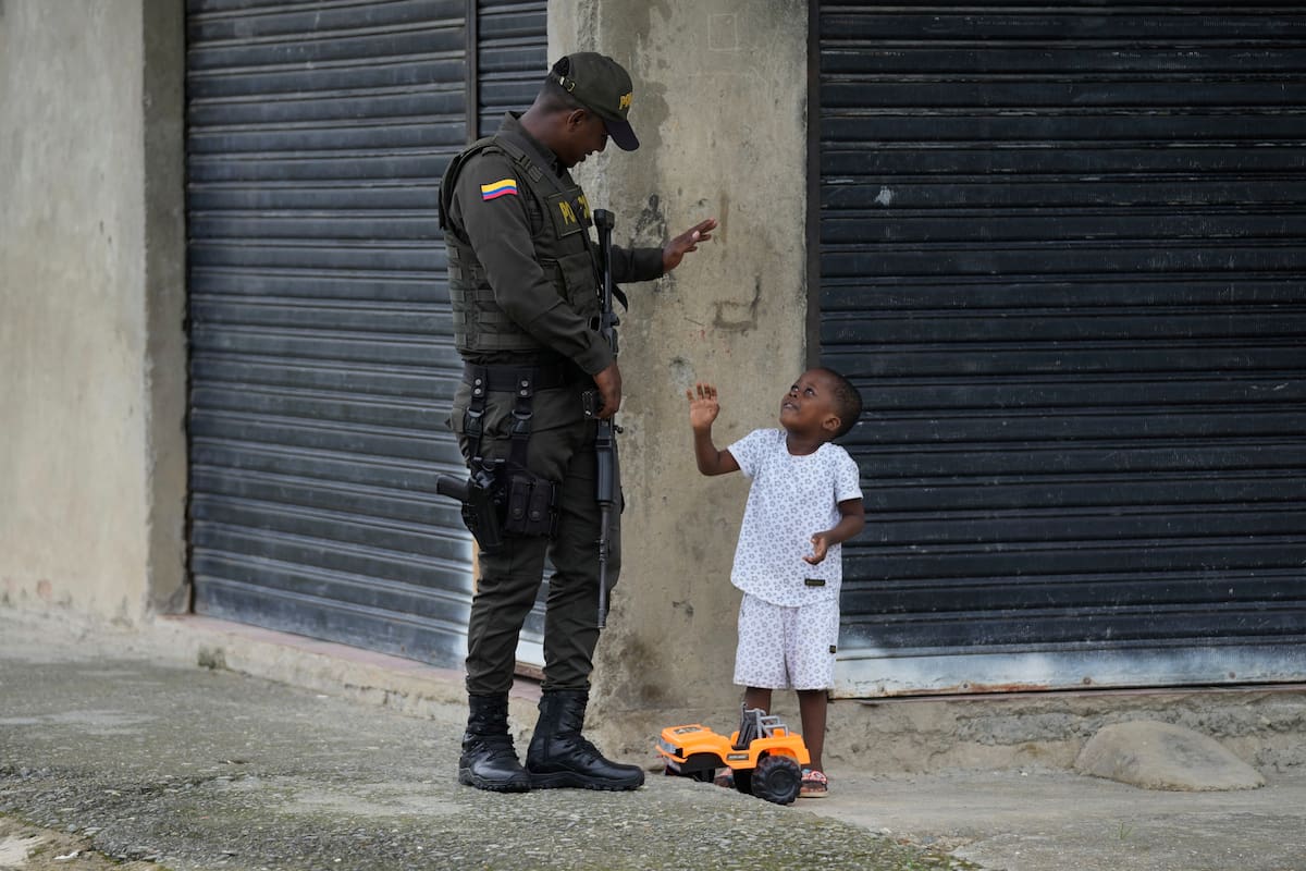 Un policía habla con un niño en un vecindario donde están presentes las bandas, en Colombia