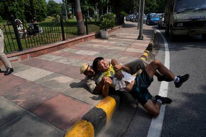 Un policía indio detiene a un exiliado tibetano durante una protesta contra la situación de derechos humanos en Tíbet, con motivo del 75to aniversario del gobierno del Partido Comunista en China, en el exterior de la embajada de China en Nueva Delhi, India, el 1 de octubre de 2024. (AP Foto/Manish Swarup)