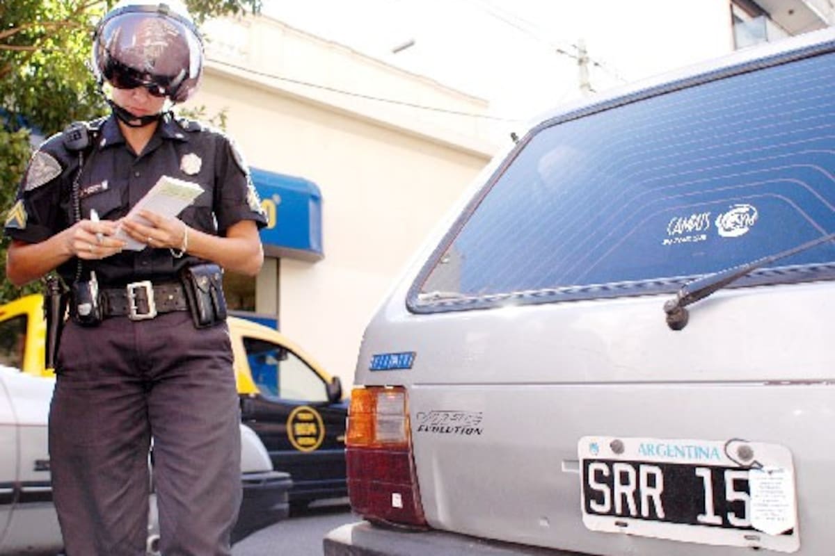 Un policía labra un acta de infracción a un auto cuya patente fue parcialmente tapada