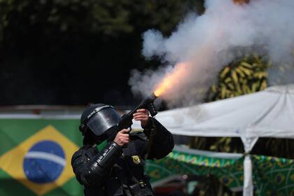 Un policía militar lanza gas lacrimógeno en un intento por dispersar manifestantes partidarios de Jair Bolsonaro que cortan una autopista en Novo Hamburgo, Rio Grande do Sul.