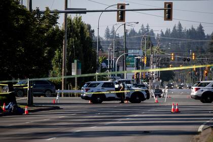 Un policía monta guardia afuera de un vehículo en el cierre de la calle en el lugar de un tiroteo en Langley, Canadá, el lunes 25 de julio de 2022. (Darryl Dyck/The Canadian Press vía AP)