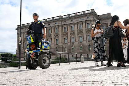 Un policía patrulla el Parlamento sueco en Estocolmo, jueves 17 de agosto de 2023. Suecia elevó su nivel de alerta antiterrorista a su segundo nivel más alto el jueves luego de varios incidentes de quema del Corán por activistas antiislámicos, los que provocaron reacciones de furia en países musulmanes. (Fredrik Sandberg/TT News Agency via AP)