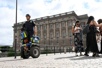 Un policía patrulla el Parlamento sueco en Estocolmo, jueves 17 de agosto de 2023. Suecia elevó su nivel de alerta antiterrorista a su segundo nivel más alto el jueves luego de varios incidentes de quema del Corán por activistas antiislámicos, los que provocaron reacciones de furia en países musulmanes. (Fredrik Sandberg/TT News Agency via AP)