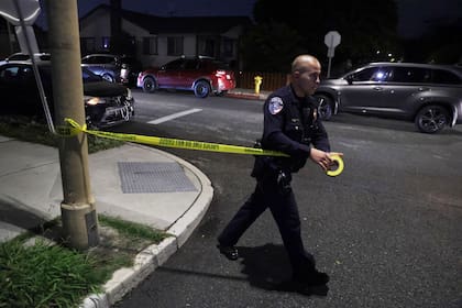 Un policía pone cinta policial cerca de una vivienda relacionada con Cole Tomas Allen, sospechoso de disparar en la Cena de Corresponsales de la Casa Blanca el sábado 25 de abril de 2026 en Torrance, California