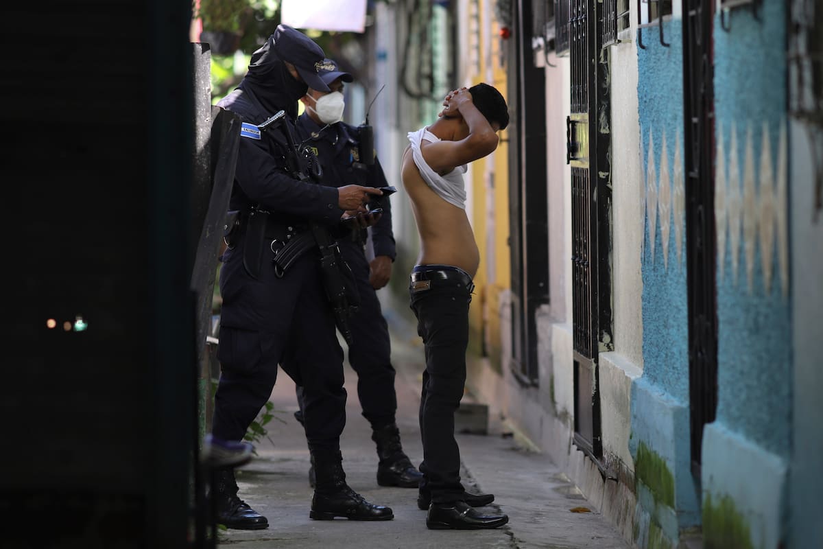 Un policía registra y comprueba la documentación de un hombre que vive en la comunidad de Kiwanis durante una patrulla preventiva contra las pandillas, en Soyapango, El Salvador. (AP Foto/Salvador Melendez)