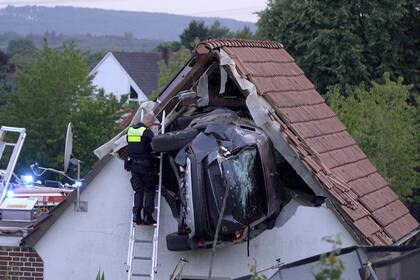 Un policía revisa un automóvil atascado en un granero después de un accidente en Bohmte, Alemania, el domingo 20 de julio de 2025. (Torben Kipp/Nordwestmedia-TV/dpa vía AP)
