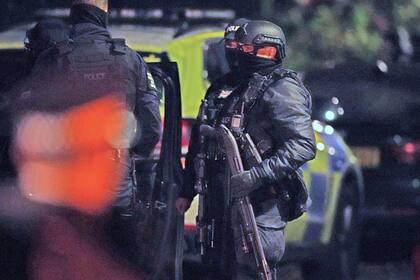 Un policía sostiene un arma para derribar puertas ante un inmueble de la Avenida Rutland, en Sefton Park,  el lunes 15 de noviembre de 2021, tras una explosión la víspera en el Hospital de Mujeres de Liverpool, en Liverpool, Inglaterra. (Peter Byrne/PA vía AP)