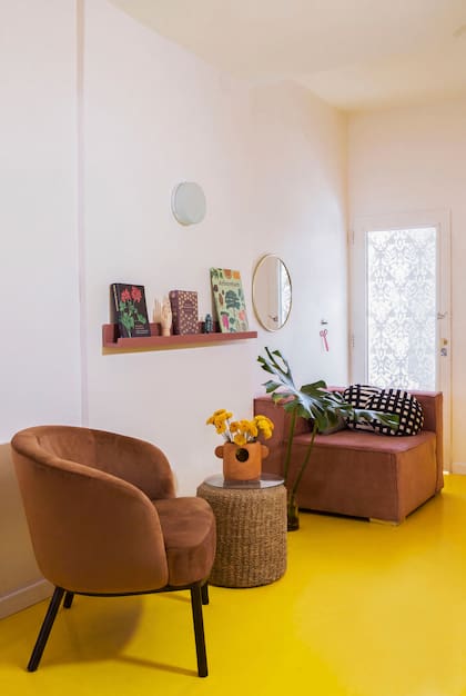 Un puf de fibras naturales oficia como mesa de arrime para sostener el florero ‘Mono’, obra de la dueña de casa (Polypunck).