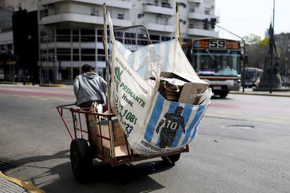 Un reciclador que vende cartón usado tira de su carrito en una calle de Buenos Aires