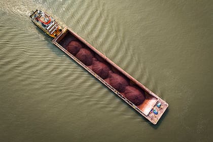 Un remolcador empuja una barcaza con carga ligera por el río Paraguay en la localidad de Mariano Roque Alonso, en las afueras de Asunción, Paraguay, el lunes 9 de septiembre de 2024. Los niveles de agua del río han caído a su máximo histórico debido a la sequía, según el Departamento de Meteorología e Hidrología de Paraguay. (AP Foto/Jorge Sáenz)