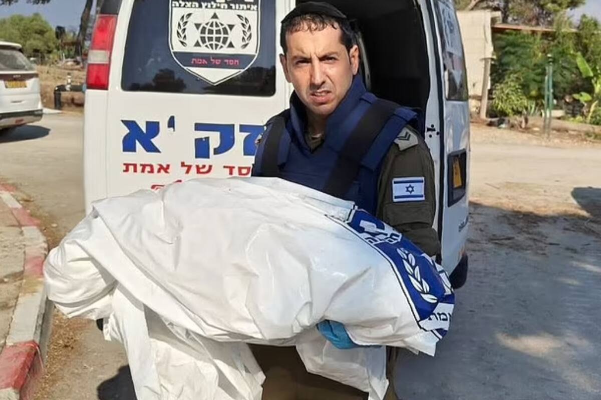 Un rescatista israelí lleva lo que parece ser un cuerpo pequeño, posiblemente de un niño, envuelto en una manta, luego del ataque múltiple de Hamas en el sur de Israel