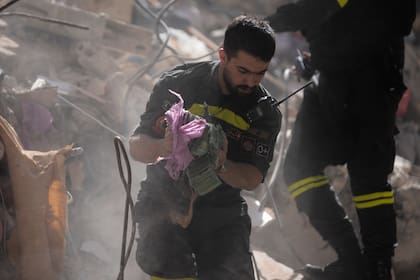 Un rescatista sostiene dinero recuperado de entre los escombros de un edificio destruido por un ataque aéreo israelí en Beirut, el Líbano, el 9 de abril de 2026