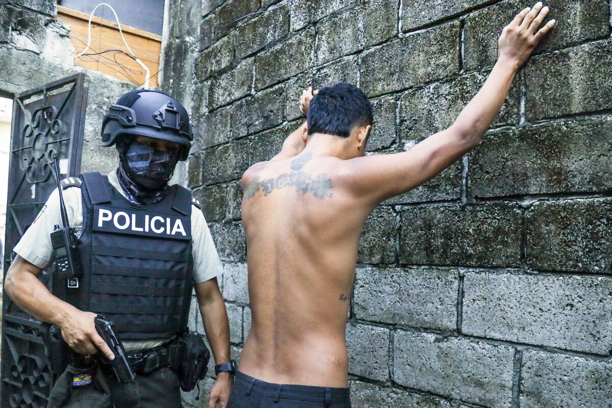 Un residente apoya las manos en un muro mientras la policía le registra para buscar armas o drogas, durante una operación contra grupos criminales en Guayaquil, Ecuador