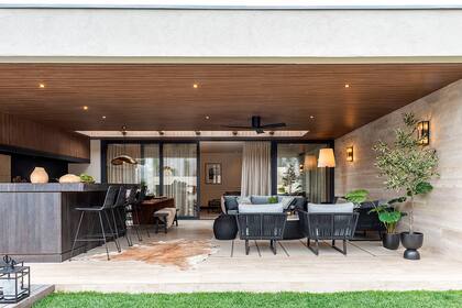 Un revestimiento de varillado de madera en el techo logra cierta continuidad visual y sensorial respecto al living.