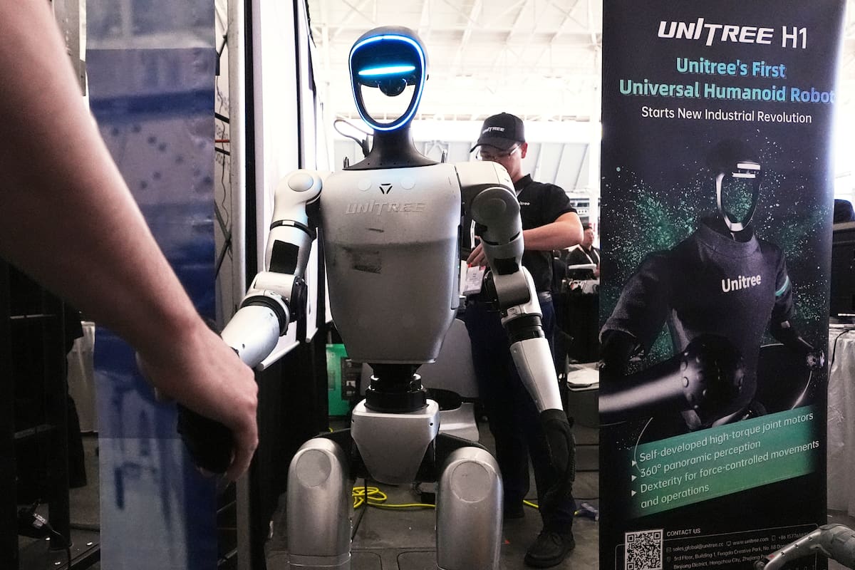 Un robot de Unitree saluda a un invitado de una convención en la Robotics Summit & Expo, el miércoles 30 de abril de 2025, en Boston. (AP Foto/Charles Krupa)