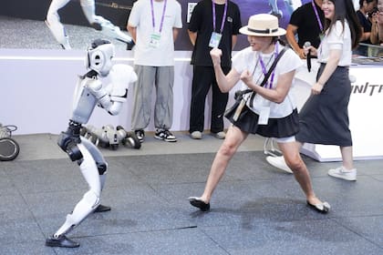 Un robot humanoide boxea con una visitante en el Centro Internacional de Convenciones y Exposiciones de Nanning, en Nanning, capital de la región autónoma de la etnia zhuang de Guangxi, en el sur de China