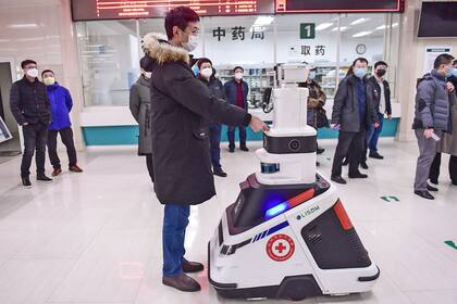Un robot que toma temperaturas y desinfecta personas recorre los pasillos de un hospital en Shenyang, China.