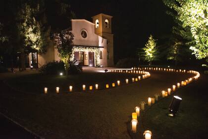 Un romántico camino alumbrado con velas conducía a la capilla, decorada con flores blancas por la ambientadora Marisa Tenguerian.