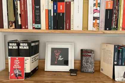 Un sacapuntas con forma de máquina de escribir y un programa de mano enmarcado cohabitan la biblioteca del autor