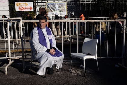 Un sacerdote espera que se acerque algún fiel a confesarse durante la celebración por el día de San Cayetano