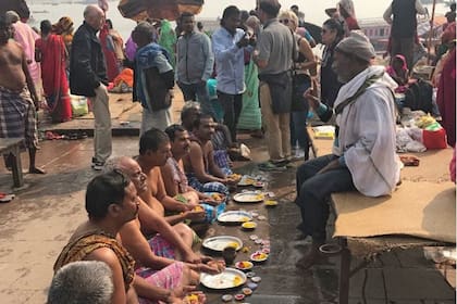 Un sacerdote y varios hombres en medio de un ritual para conmemorar a sus ancestros fallecidos