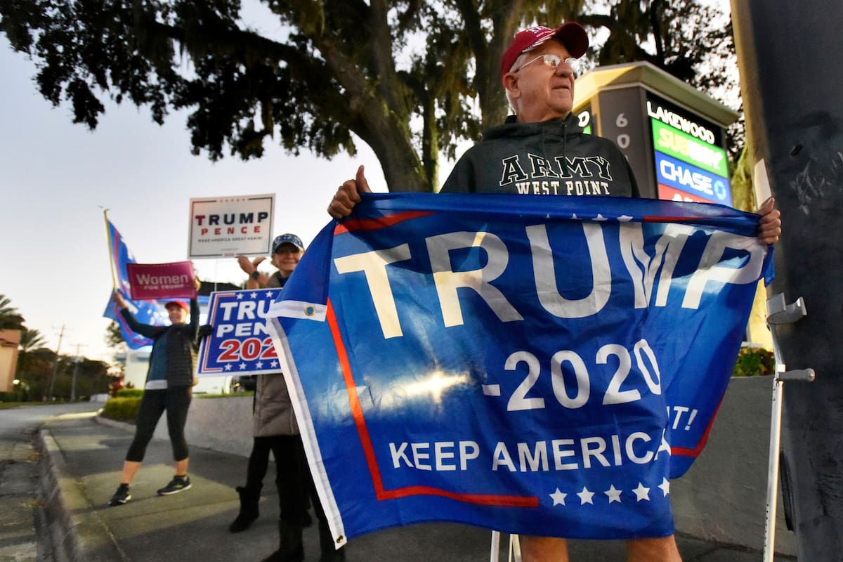 Un seguidor de Donald Trump sostiene una bandera en Jacksonville, Florida