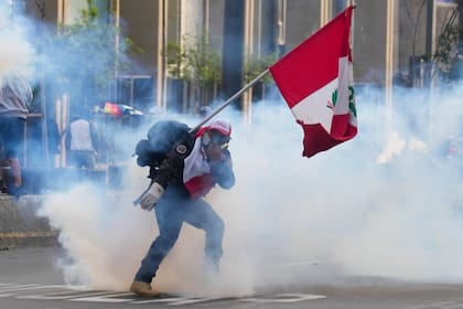 Un simpatizante del destituido presidente Pedro Castillo devuelve un contenedor de gas lacrimógeno en dirección a la policía, el lunes 12 de diciembre de 2022, en Lima, Perú. (AP Foto/Martin Mejia)