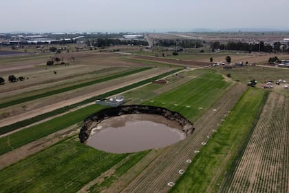 Un socavón con agua en el fondo continúa creciendo en un campo agrícola en Zacatepec, en las afueras del estado de Puebla, México, el martes 1 de junio de 2021. (AP Foto/Pablo Spencer)