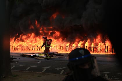 Un socorrista llega a un incendio provocado frente a un edificio durante una manifestación, el lunes 1 de mayo de 2023 en París.