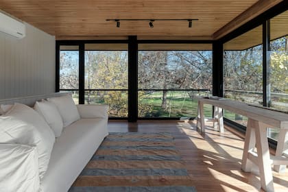 Un sofá y un tablón de madera: nada más necesita este espacio, en el que sobra con acostarse a contemplar el frondoso arbolado.