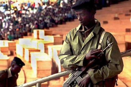 Un soldado frente a los ataúdes de algunas de las víctimas del genocidio.