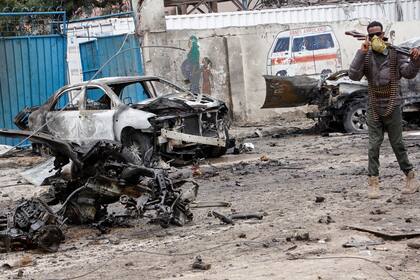 Un soldado somalí monta guardia junto a los restos de un auto después de un ataque con coche bomba en un retén del Palacio Presidencial de Somalia, el sábado 25 de septiembre de 2021, en Mogadiscio. (AP Foto/Farah Abdi Warsameh)